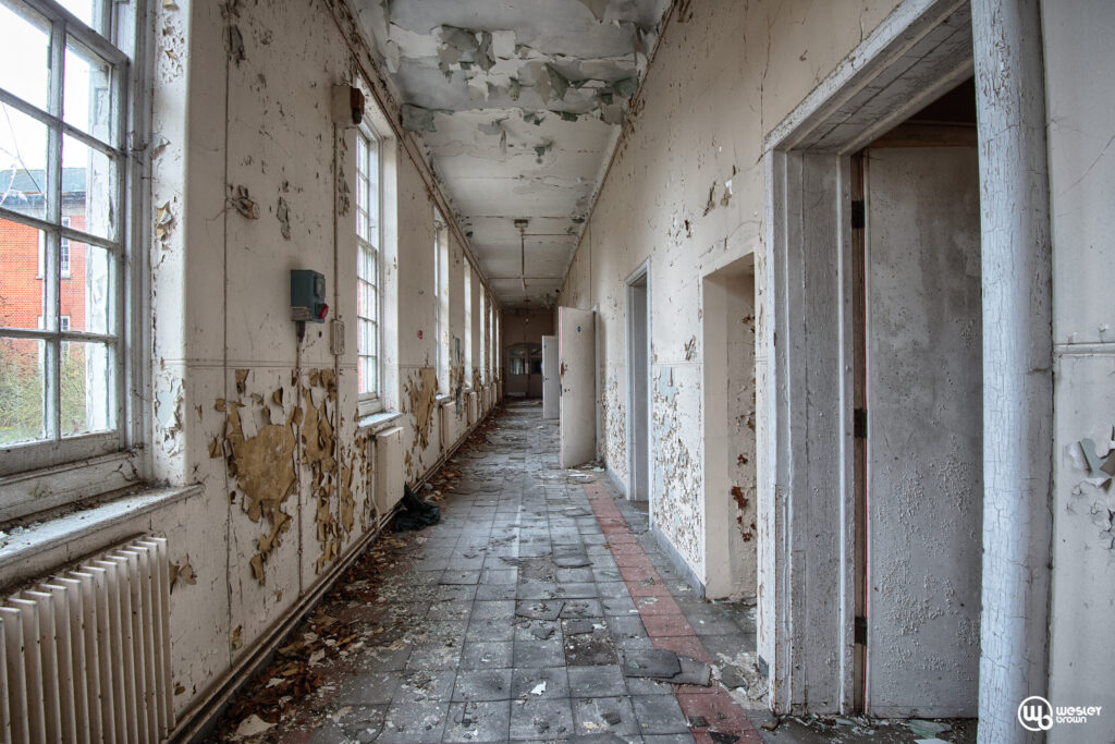 Long abandoned corridor inside Severalls Mental Hospital during an urban exploration in Colchester, Essex.