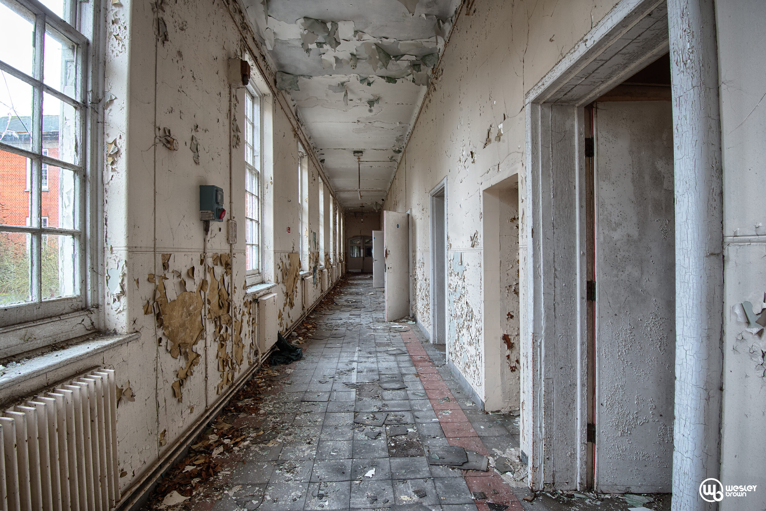 Long abandoned corridor inside Severalls Mental Hospital during an urban exploration in Colchester, Essex.